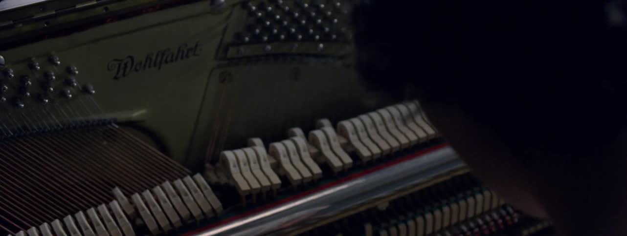 A person plays the piano while the inner keys move