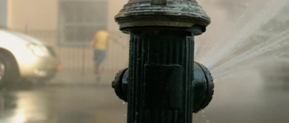 A clip of an hydrant splashing water on the street