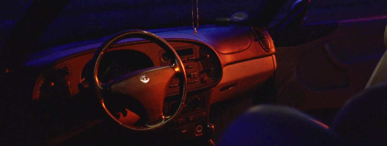 A car dashboard illuminated only by the passing light of a flashlight