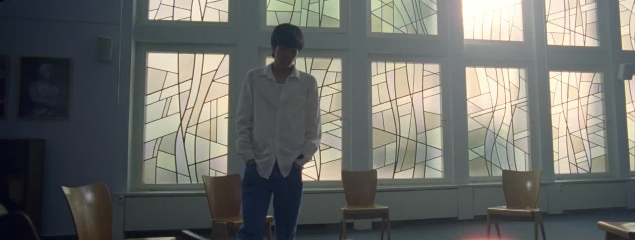 A man pacing and waiting inside a circle of empty chairs