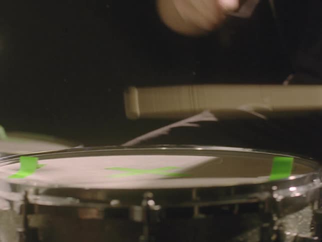 A man is beating the drums of the drums with drumsticks