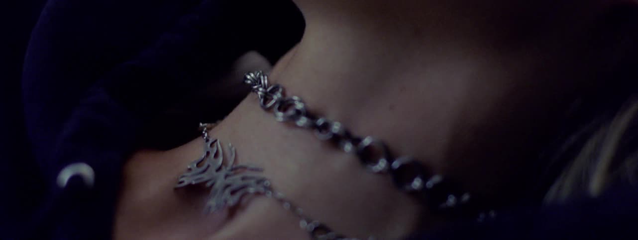 A clip of a pendant on a persons neck