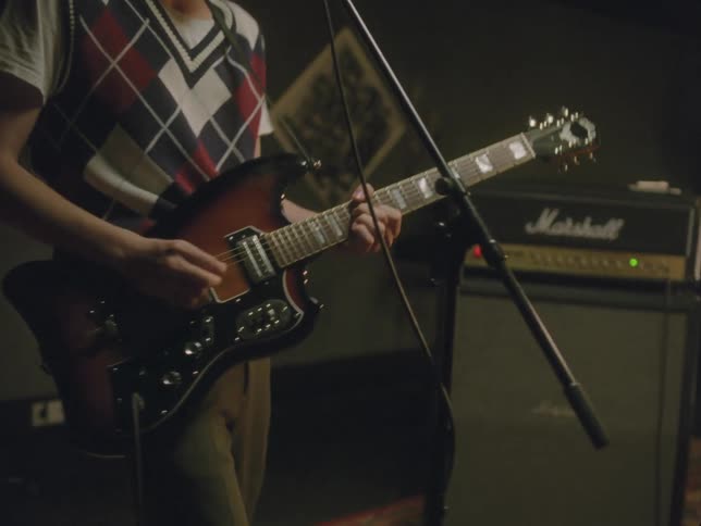 Male guitarist playing with his band sings