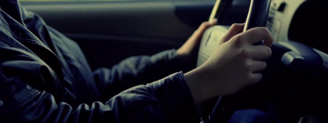 A person wearing a leather jacket drives a vehicle