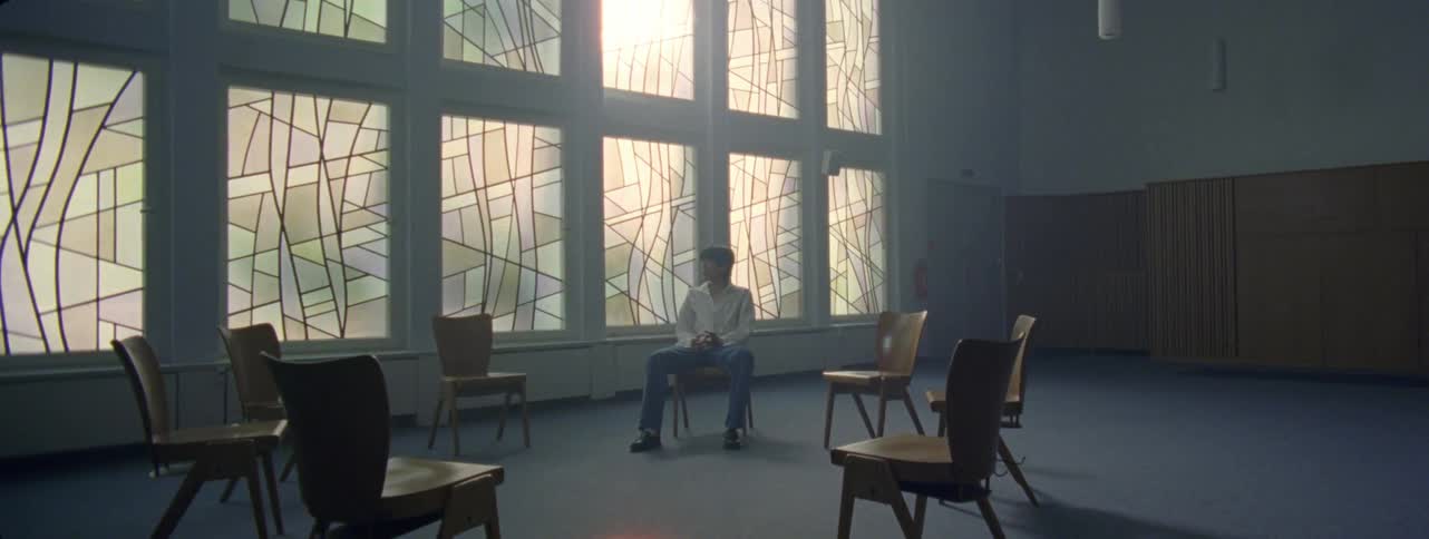 A man sits on a chair in a room
