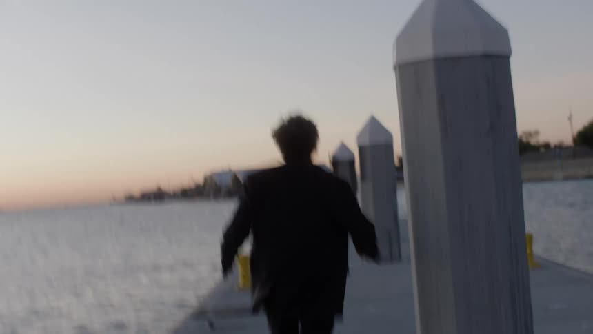 A man is frantically running on the pier