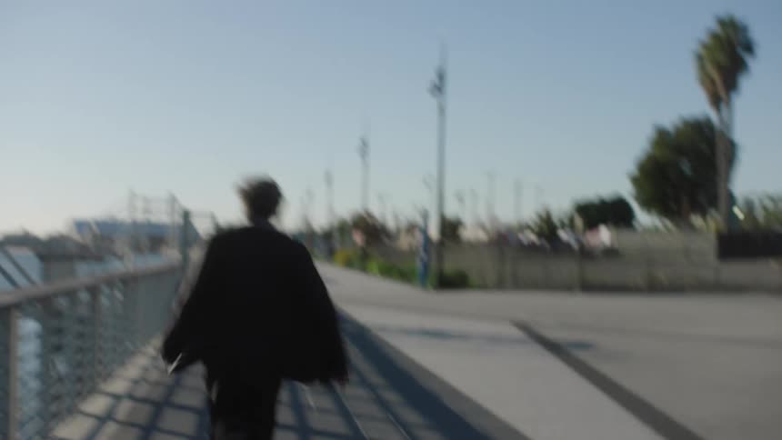 Man in suit running on sidewalk by the sea