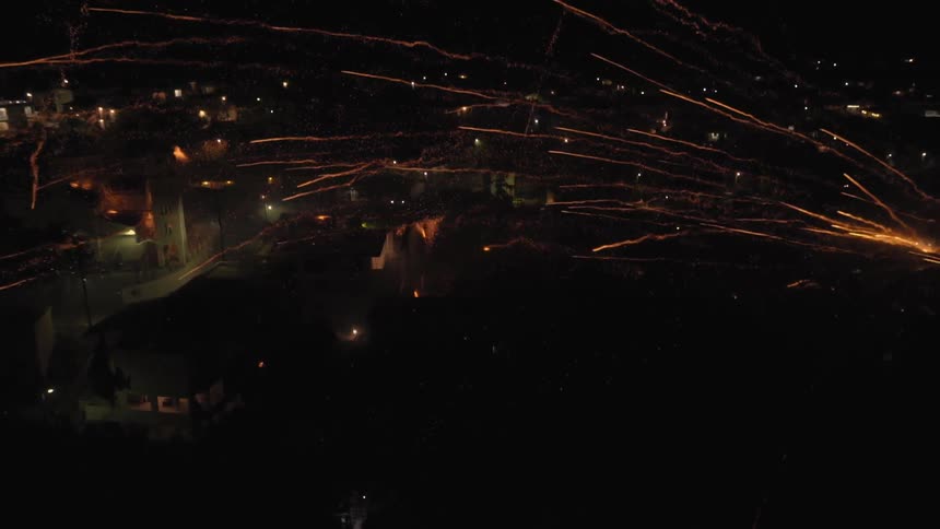 Fireworks are launched over a city at night