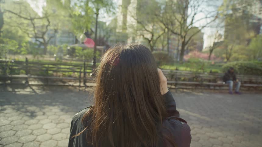 A woman drinks coffee in the park