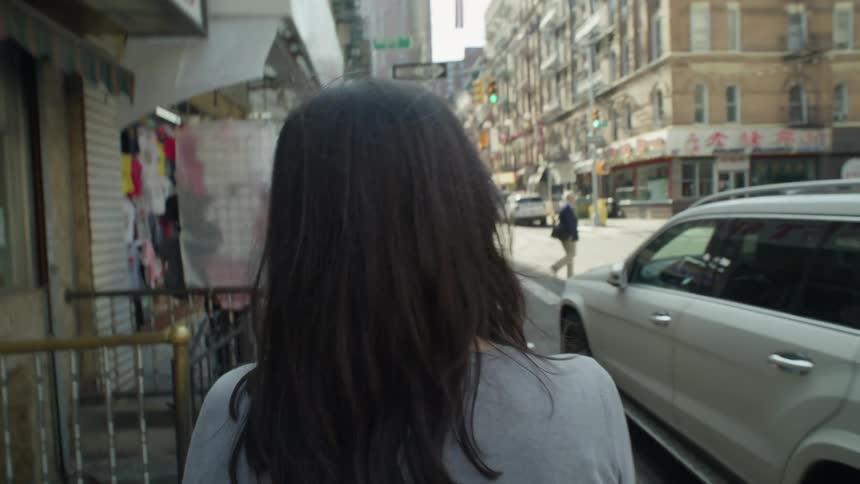 POV of a woman walking in the downtown area of a city