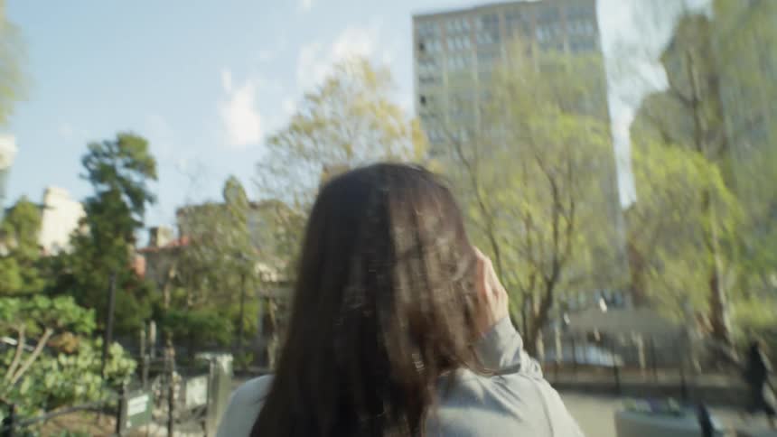 A woman saunters through a city park