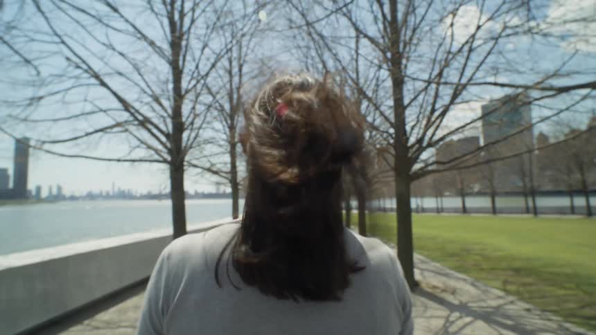 A woman is walking in the park on a windy day