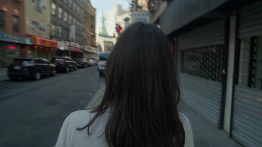 Woman walking on the sidewalk on a street in NYC