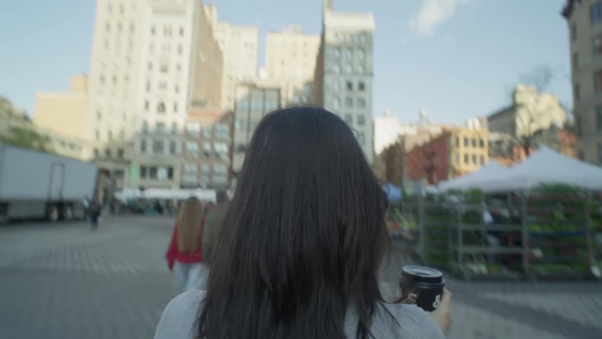 A back clip of a lady walking in the community market