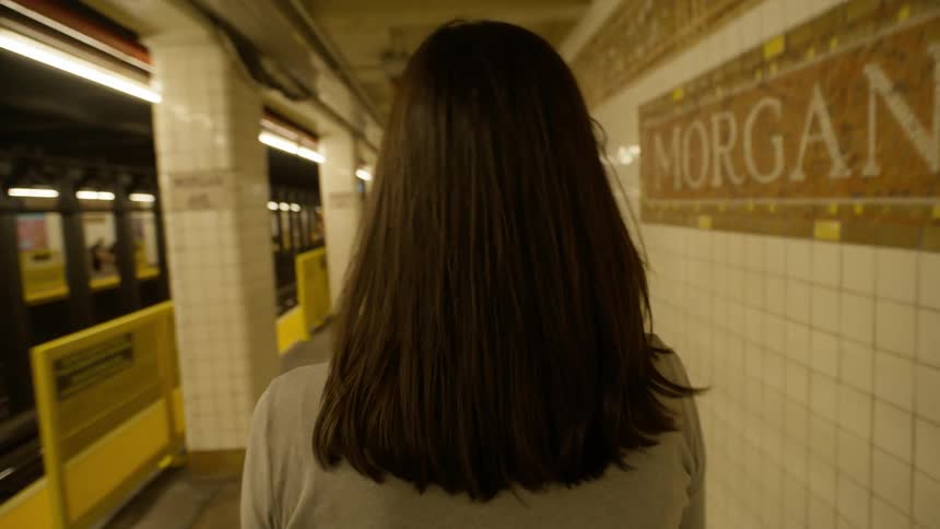 Back view of a woman walking in an indoor metro station
