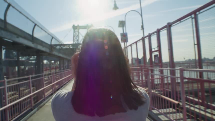A woman is walking over the bridge