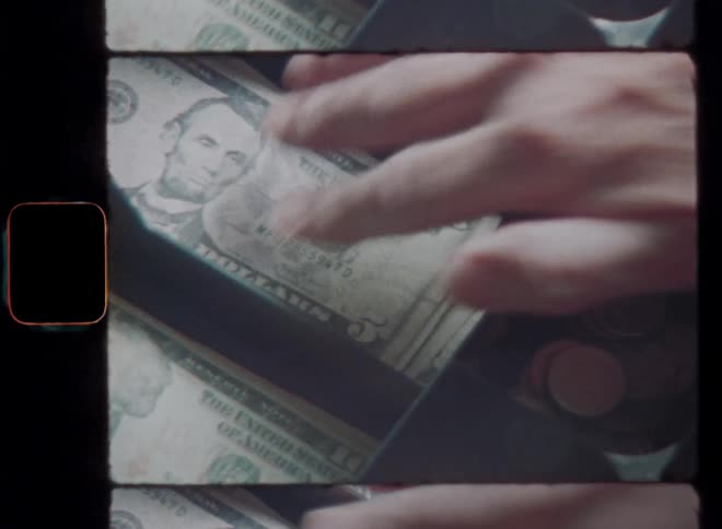 Vintage Super 8mm film footage closeup of a cash register with a mans hand putting an American 5 or five US dollar bill into the drawer next to cent coins and closing the tray with dynamic camera movement