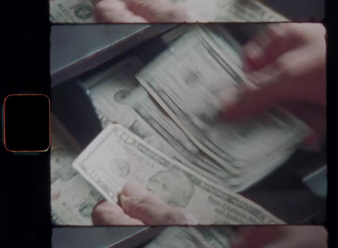 Closeup of a persons hands placing or sorting organized United States of America dollar bills into a cash register standing on a wooden counter of a small business or store on nostalgic Super 8mm film