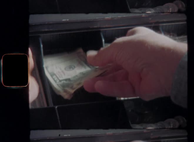 Hands of elderly man with gray hair counting US dollar bills and putting the money into an old cash register machine while checking his finances and doing the bookkeeping of his local business store or household