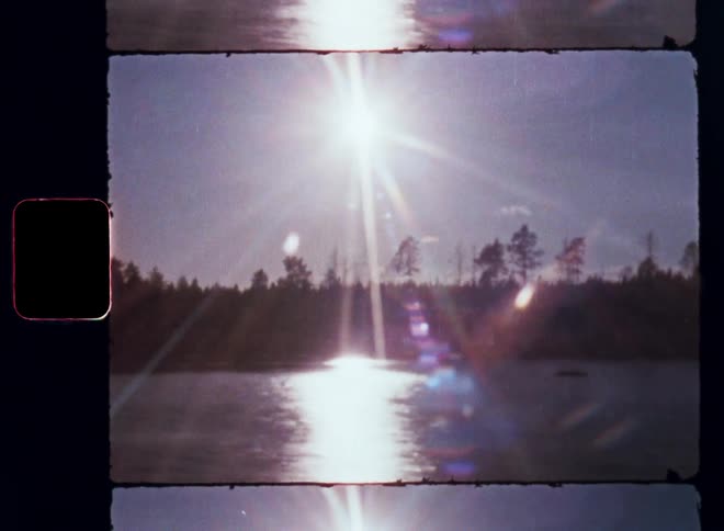 Passing or driving on a bridge over a lake or river in stunning landscape with forest and trees as the bright sunlight or sunshine is reflecting on the surface of the water during a road trip through the beautiful nature of northern Sweden or Scandinavia