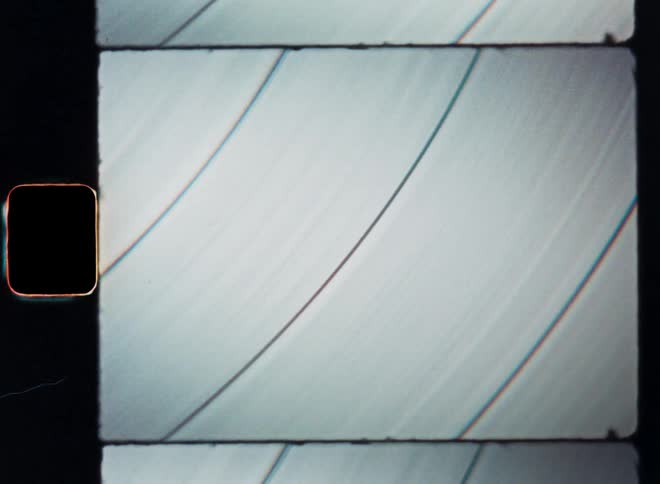 A black vinyl record with reflecting surface or abstract dark round object is spinning around in circles as the bent lines slowly move in a dynamic way with motion and the moving texture is endlessly rotating on the turntable