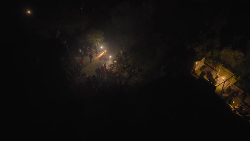A group of men shoot off an orange flare