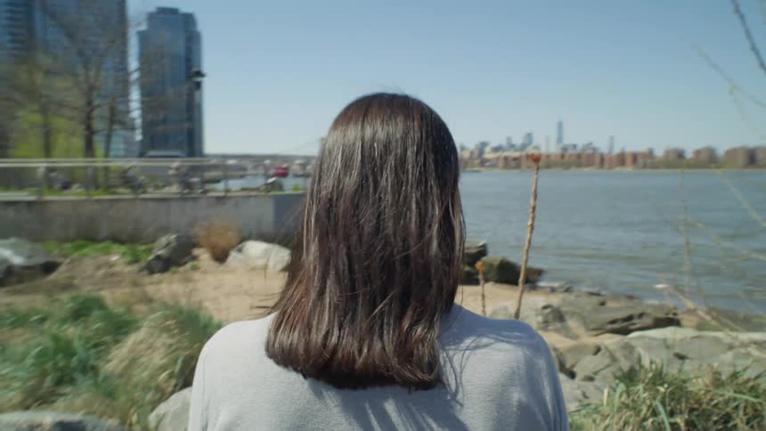 Point of view of a woman walking the rocky shoreline near New York City