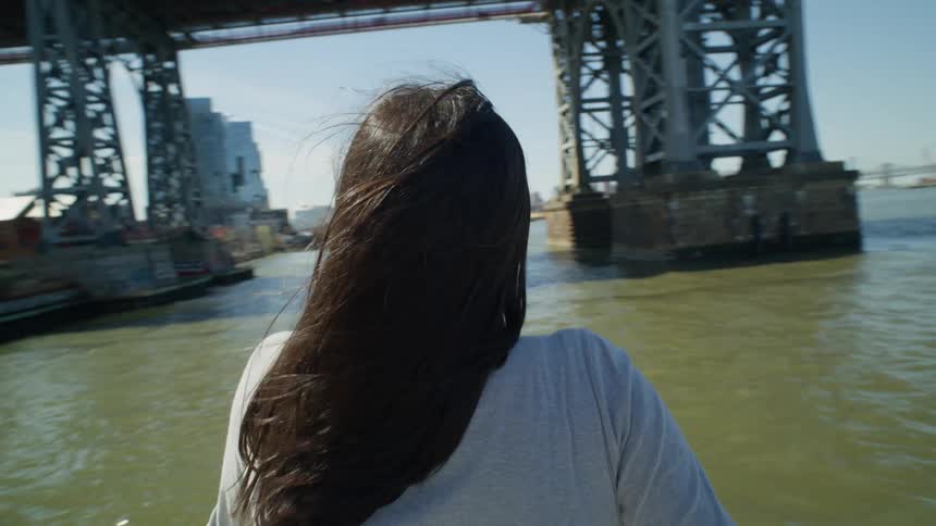A tourist looks over the water at New York City