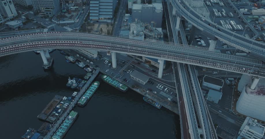 Static aerial shot of vehicles traversing overpasses through the Tokyo cityscape