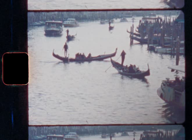 Several canoes with tourists functioning as water taxis for transportation are floating or driving to the other shore of a maritime canal with seagulls flying and the sun setting in the evening time of a summer day