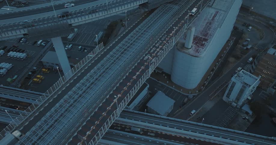 Aerial panorama of intersecting freeway overpasses with vehicle traffic in Tokyo at blue hour