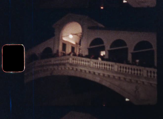 Hundreds of people or tourists silhouetted against the night sky walking on the famous rialto bridge in Venice Italy representing impressive Mediterranean architecture