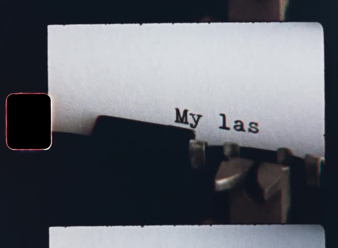 The dramatic words My Last Will are typed with a retro typewriter as an unrecognisable person is writing or typing a testament in case he or she dies on S8 film footage