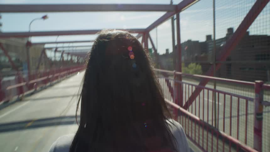 A woman on the pedestrian walkway of the Williamsburg Bridge in New York City