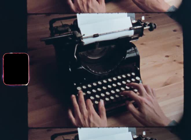 An unrecognizable man or woman in a grey shirt sitting at a wooden desk using an old vintage mechanical typewriter to write a letter in a dark room on nostalgic 8mm film with a retro vibe and grain
