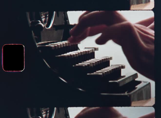 Closeup of the silhouette of hands typing fast with high speed as the fingers hit the keys with precision on a vintage typewriter in front of bright background on retro Super 8 film symbolizing old technology