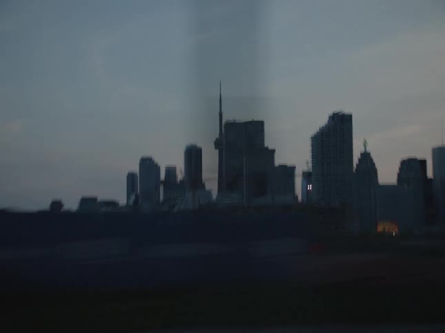 A region of a city with several tall buildings seen from a moving vehicle