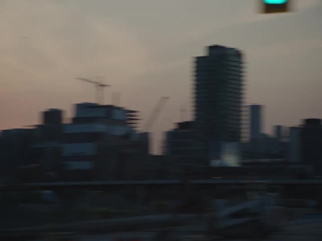 Moving view of a metropolitan city with urban and commercial buildings in an evening sky