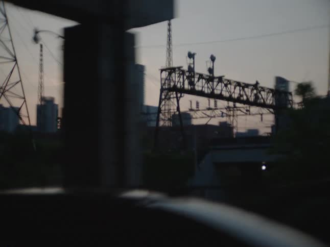 City skyline seen from a vehicle driving on a highway at dusk