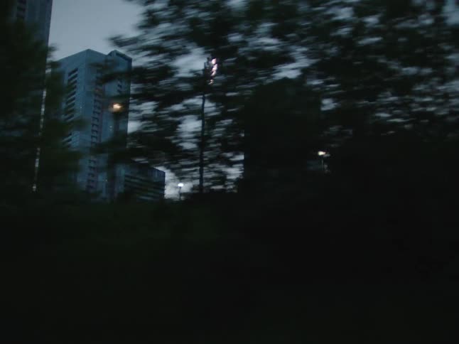 Tower blocks are visible from a moving vehicle