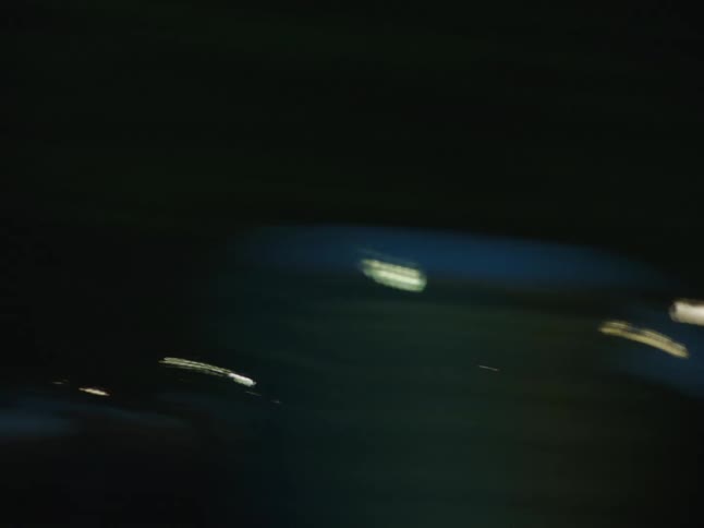 Shaky chaotic footage of city buildings seen from a moving vehicle at dusk
