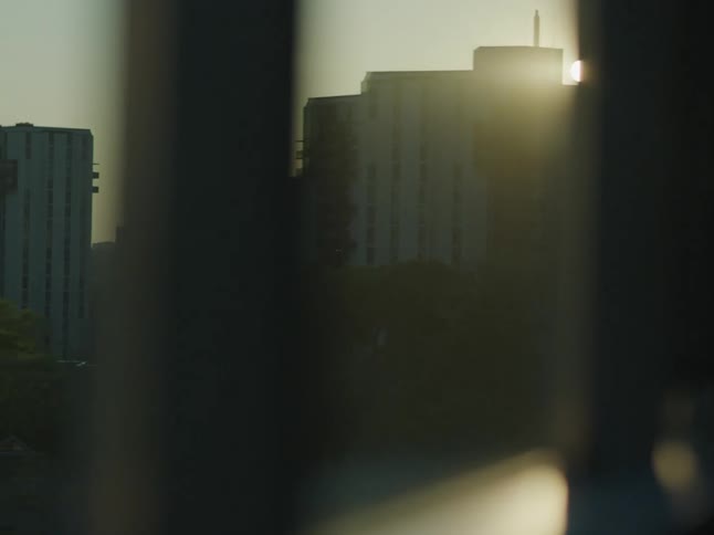 View from the slit of a window with solar reflection and residential and commercial buildings