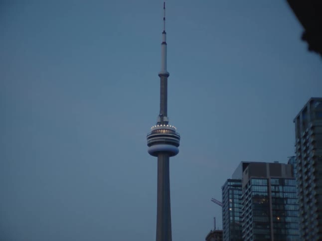 An exterior view of the cn tower and surrounding buildings in the city