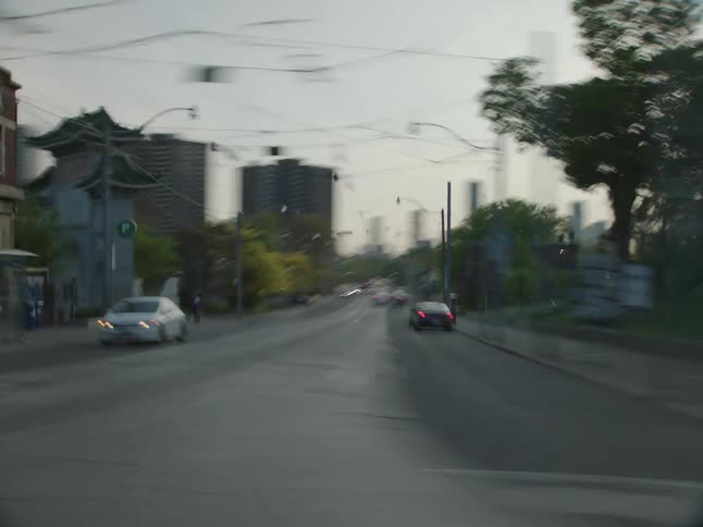 Moving view of a city streets with shops and vehicle traffic