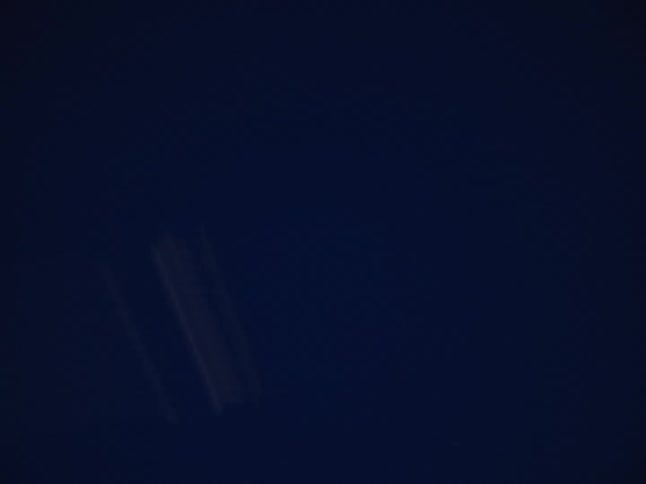 Power line passes overhead between streetlights at night