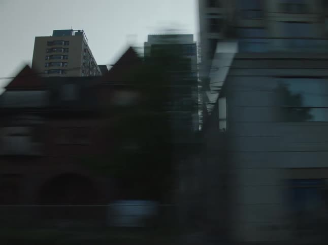 Buildings and vehicles flash by on a drive through a city
