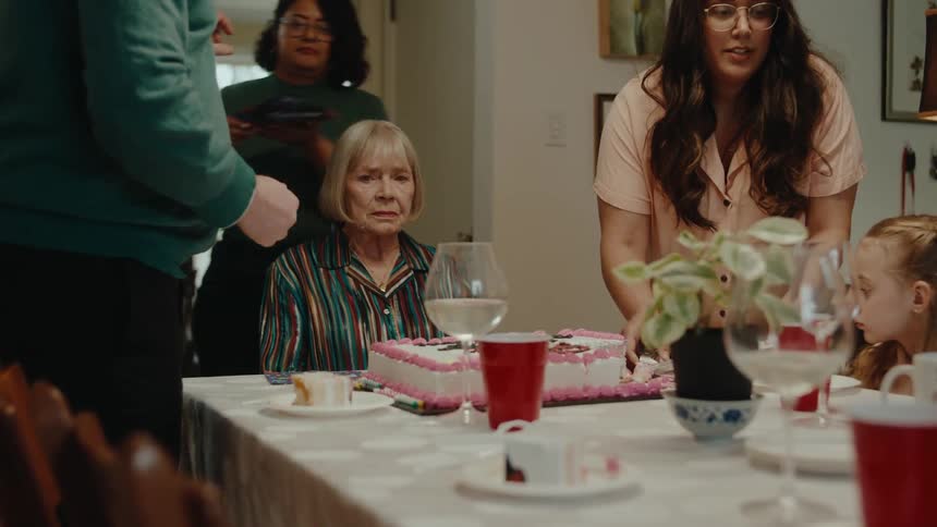 A woman looks sad at her birthday party