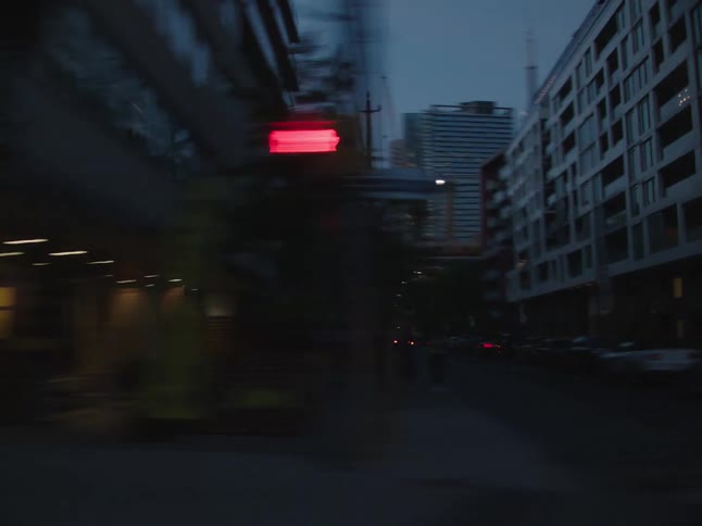 A vehicle drives down the downtown area in the city with tall buildings