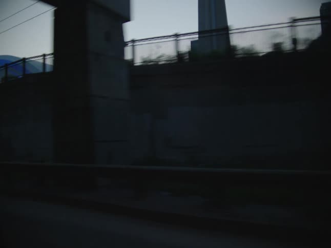 Tall buildings are visible from a train moving along the tracks