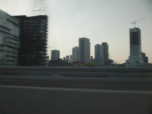 Tower blocks seen from a vehicle driving on a highway